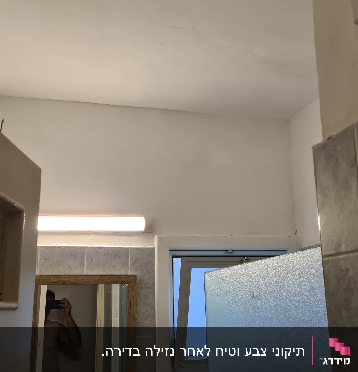 קיר צבוע בלבן עם תאורה עליונה